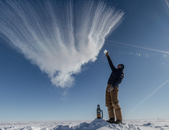 Mann lässt Wasser in der Luft gefrieren