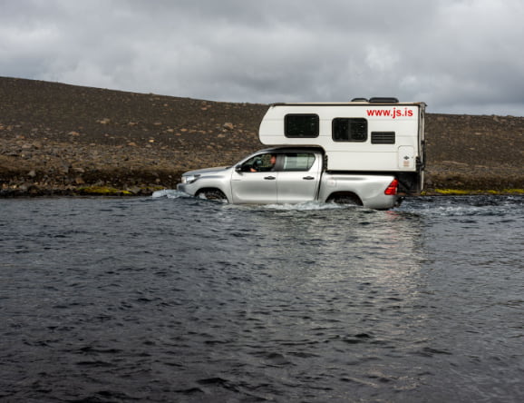 Auto fährt durch Fluss