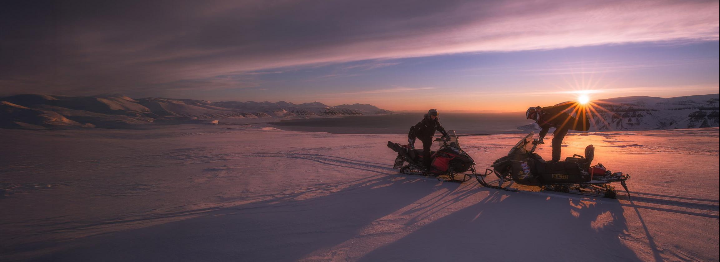 Zwei Schneemobile Sonnenuntergang