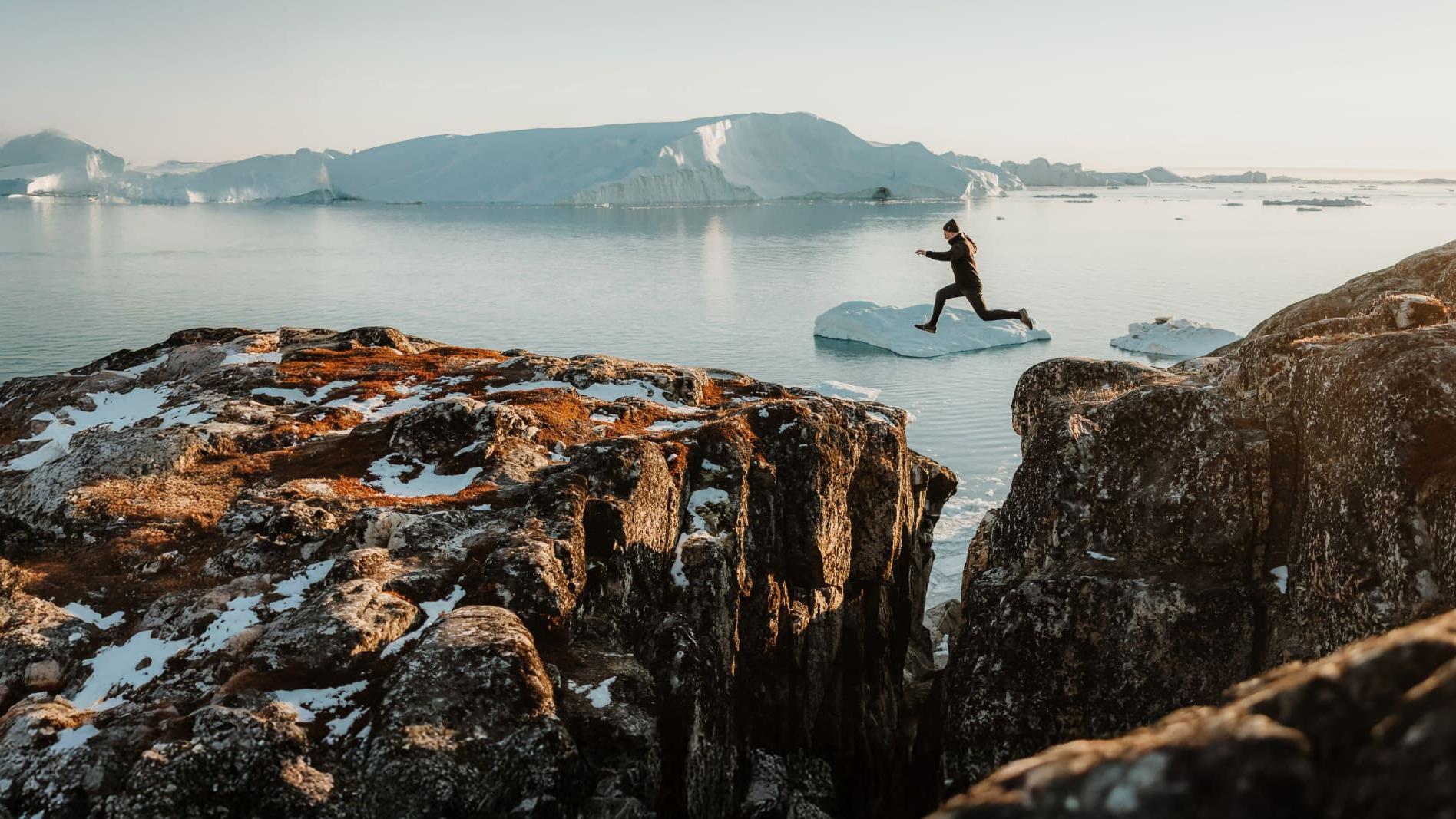 Mensch springt über Felsspalte