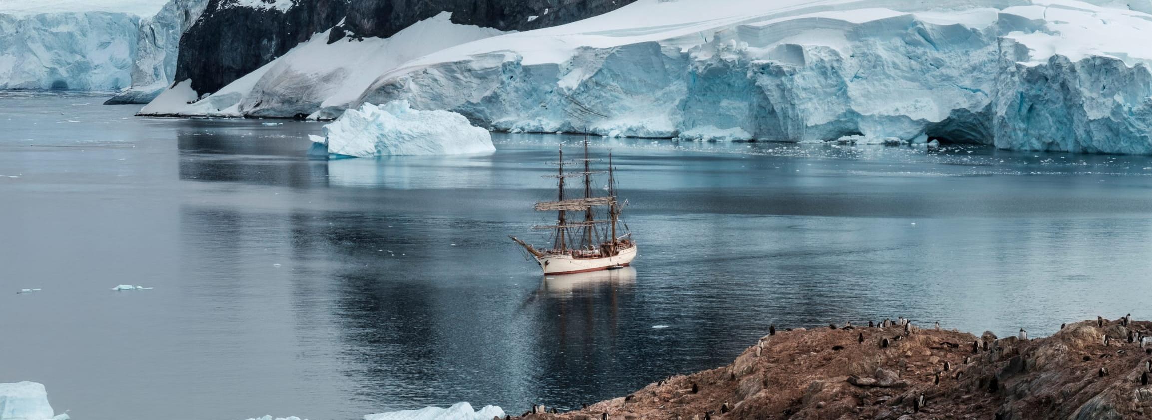 Segelschiff in Bucht vor Gletscher