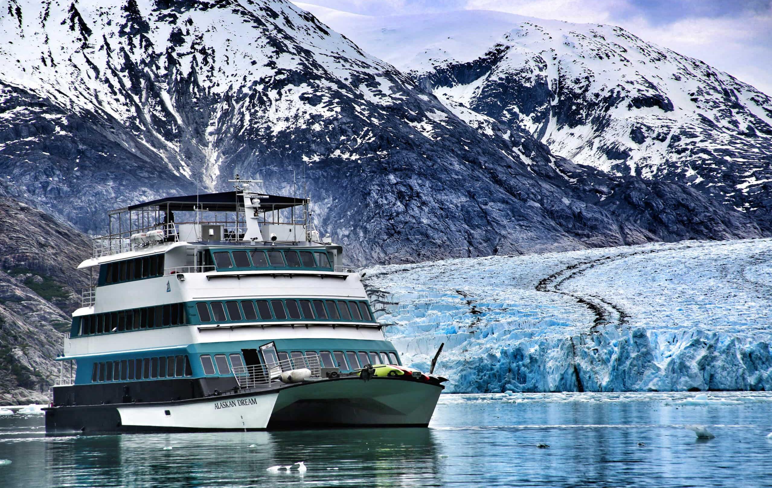 Alaska – Kreuzfahrt durch majestätische Fjorde - Schiff Alaskan Dream vor einem Gletscher und schneebedeckten Bergen